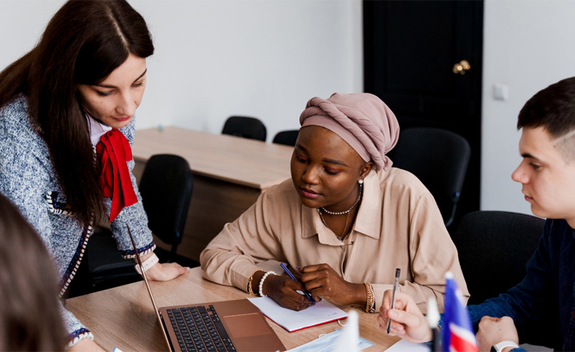 People looking at laptop and making notes